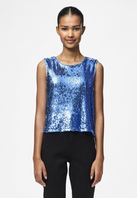 Top sans manches en sequins bleus avec un col rond, présentant un design court et une coupe ample. Les sequins reflètent la lumière, ajoutant de la texture.