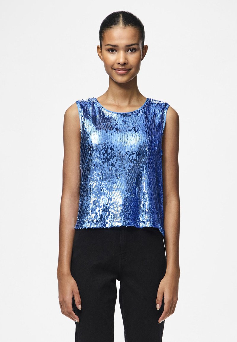 Top sans manches en sequins bleus avec un col rond, présentant un design court et une coupe ample. Les sequins reflètent la lumière, ajoutant de la texture.