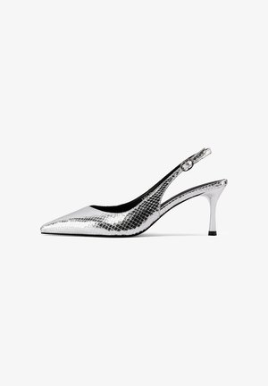 Tacchi slingback argento con punta affilata, realizzati in materiale testurizzato e lucido che ricorda la pelle di serpente. Presentano un tacco sottile e una cinghia alla caviglia.