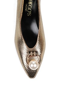 Metaliczny złoty, teksturowana górna część z zakończeniem w szpic. Posiada okrągły złoty akcent z białą perłą, czarne wnętrze. Elegancki design.