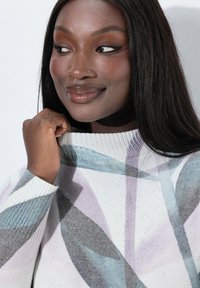 Sweter z żebrowanym dekoltem, z kolorowym, abstrakcyjnym wzorem w odcieniach szarości, bieli i delikatnych pasteli, z subtelnymi akcentami brokatowymi.