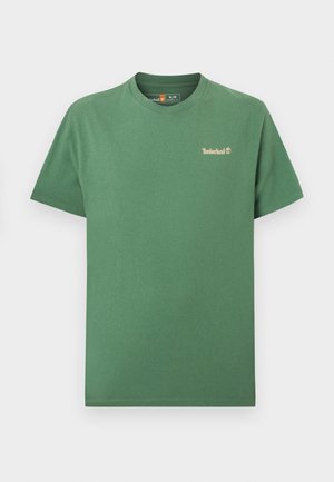 Tricou verde din bumbac cu guler rotund și mâneci scurte. Prezintă un mic logo Timberland bej pe partea stângă a pieptului. Textură netedă.