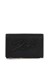 Portefeuille en cuir noir avec une surface texturée, présentant le logo "Karl" en relief dans un style manuscrit et une fermeture éclair argentée.