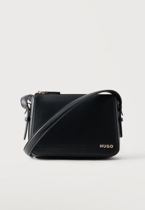 Sort rektangulær læder crossbody taske med justerbar rem og guld "HUGO" logo på frontens hjørne mod en ensfarvet baggrund.