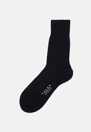 Calzino di cotone nero con una cuffia a coste, texture liscia e tallone rinforzato. Presenta il marchio stampato in bianco di lato.