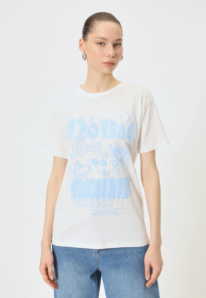 Hvid bomulds T-shirt med blå grafisk tekst "No Bad Days Good Energy" og dekorative elementer. Casual pasform og korte ærmer.