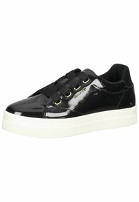 Zapatillas de charol negras con suela de goma blanca, con cordones negros y ojales en tono dorado. Detalle del logo en el costado.