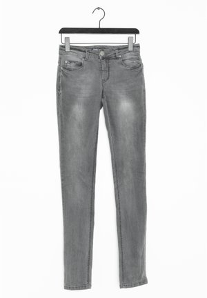 Grå slim-fit jeans med forlommer og knaplukning, hængende på en sort bøjle mod en hvid baggrund.
