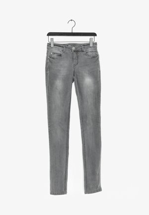 Szare jeansy slim fit z przednimi kieszeniami i zapięciem na guziki, wiszące na czarnym wieszaku na białym tle.