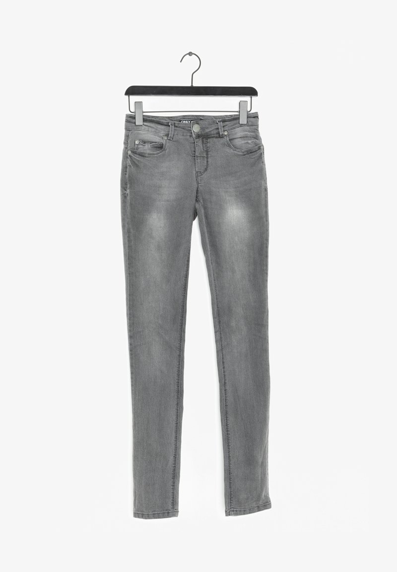 Jean slim gris avec poches avant et fermeture par boutons, suspendu sur un cintre noir sur fond blanc.