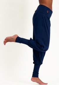Marineblaue Jogginghosen aus weichem Stoff. Sie verfügen über einen hohen Bund, schmal zulaufende Knöchel und ein gerafftes Design an den Bündchen.