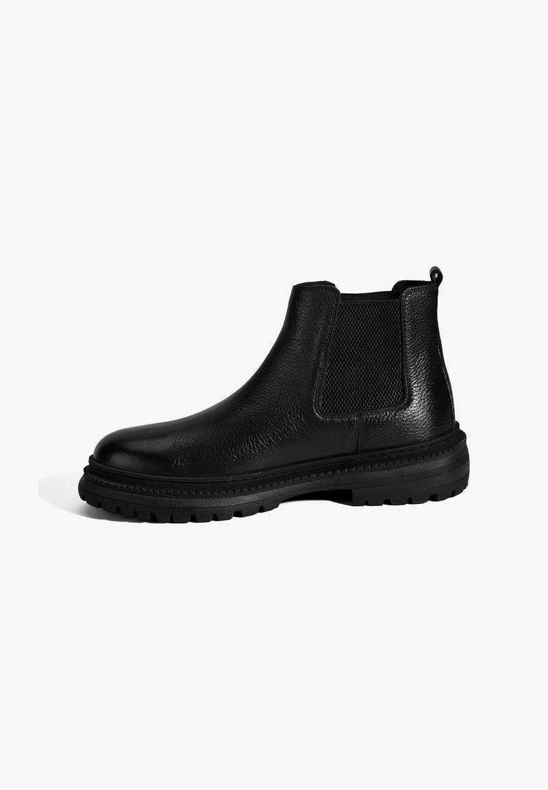 Bottes Chelsea en cuir noir avec un dessus texturé, des panneaux latéraux élastiques, une boucle de tirage et une semelle en caoutchouc épaisse avec des motifs anti-dérapants.