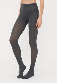 Mørkegrå leggings lavet af elastisk materiale, med en sømløs talje og en glat tekstur, designet til et tætsiddende look.
