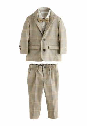 Costume à carreaux brun clair comprenant une veste cintrée à deux boutons, une chemise blanche et un pantalon ajusté assorti avec une taille élastique.