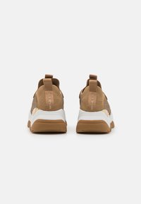 Brown mesh sneakers with white and tan rubber soles. Features a textured design and pull tabs on the heel for easy wear.