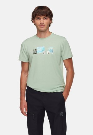 Lichtgroene T-shirt met korte mouwen, voorzien van een grafische print met verschillende natuurafbeeldingen in blauwe en zwarte tinten op de borst.