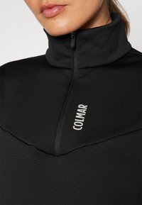 Pullover nero con zip e colletto alto, caratterizzato da un design a pannelli a contrasto e logo "COLMAR" in bianco, realizzato in un tessuto morbido.