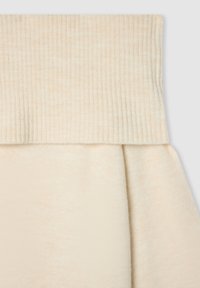 Maglione color crema con colletto a coste ripiegato e una texture morbida e liscia. Il corpo è leggermente arricciato per una vestibilità rilassata.