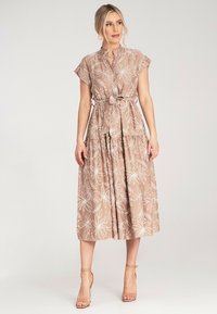 Maxikleid aus hellbraunem Stoff mit weißen Blumenmuster, kurzen Ärmeln und einem Bindegürtel in der Taille, mit einem gestuften Rockdesign.