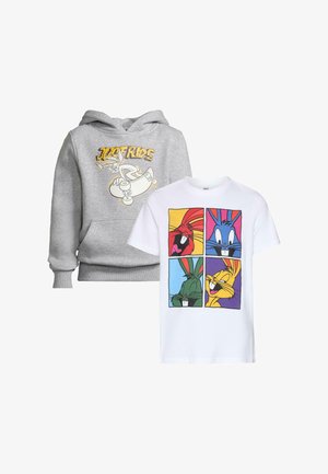 Biała bawełniana koszulka z kolorowymi grafikami postaci z kreskówek w czterech kwadratach; zestawiona z luźnymi niebieskimi spodniami cargo z dżinsu i żółtymi butami.