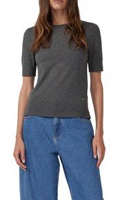 Grijs, kortemouw tricot top met een ronde halslijn, kenmerkt zich door een subtiele ribbeltextuur. Gecombineerd met loszittende blauwe denim jeans.