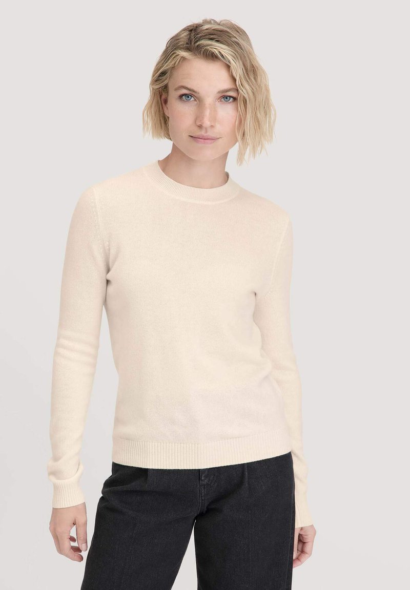 Hellbeige Pullover mit Rundhalsausschnitt und langen Ärmeln. Aus weichem, strukturiertem Stoff mit gerippten Bündchen und Saum gefertigt. Trägt man mit dunklen Jeans.