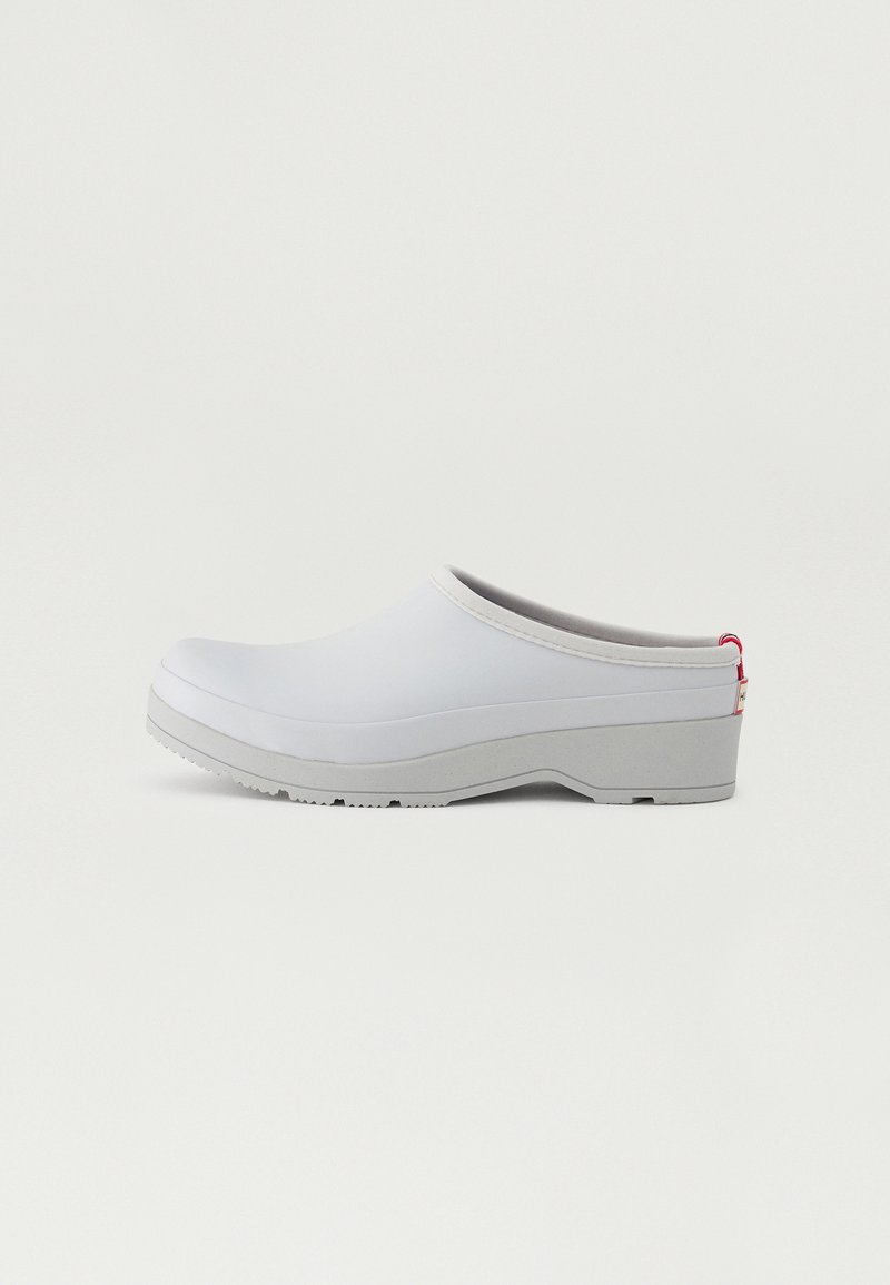 White plastic clog with a rounded toe, grey sole, and red accent at the back. Smooth texture with a slight sheen, elevated heel for support.