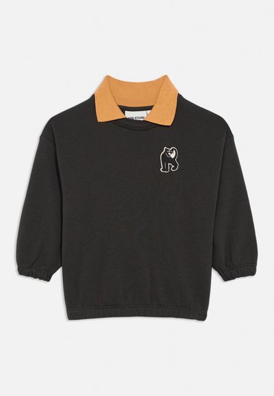 Sweat-shirt noir à manches longues avec poignets élastiques, col côtelé marron, et petit patch gorille noir et blanc sur le côté gauche de la poitrine.