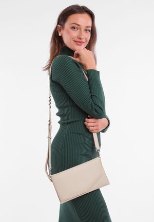 Beige Leder Umhängetasche mit einem dreieckigen Klappdeckel und silbernem Metall, ausgestattet mit einem verstellbaren Riemen und einer glatten Textur.