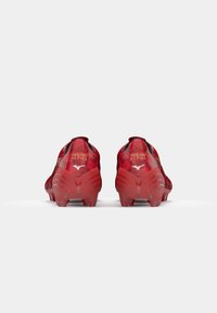 Rote Mizuno Alpha Fußballschuhe mit einer strukturierten Oberseite, einem markanten Fersendesign und einem geformten Stollenmuster für besseren Halt.