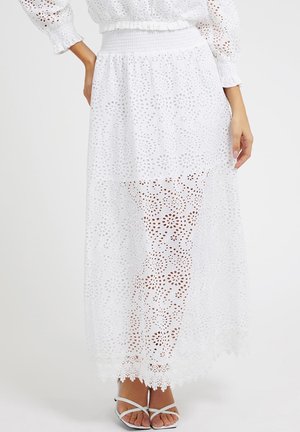 Jupe maxi blanche avec un motif de jour échelle élaboré et un ourlet festonné. Présente un design à volants et une taille élastique pour un look ajusté.