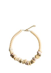 Collier en perles composé de perles lisses de couleur crème avec des accents irréguliers de brun clair. Quincaillerie dorée et détail de chaîne ajustable.