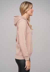 Felpa rosa con cappuccio e tasca frontale, caratterizzata da un design floreale ricamato, polsini a costine e una vestibilità comoda.