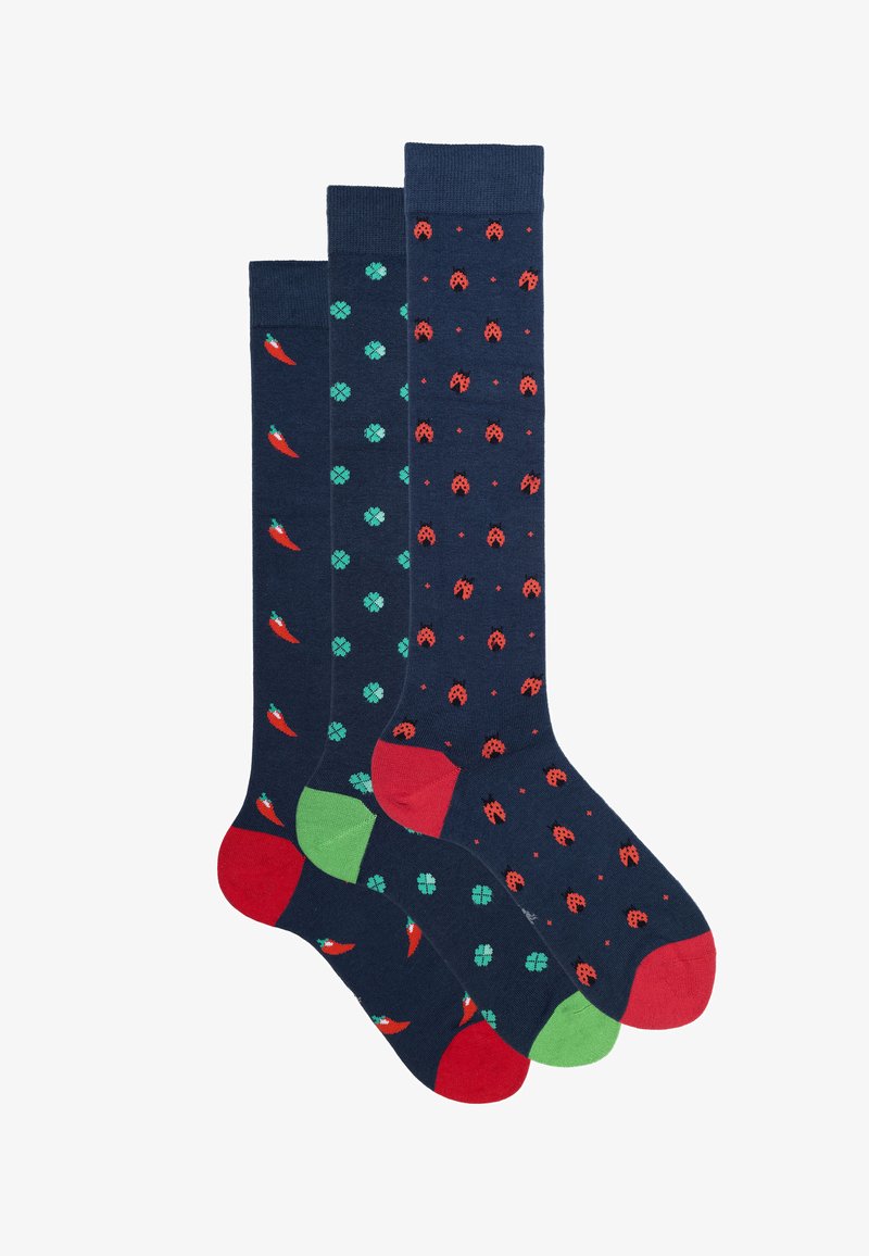 Drei Paar knielange Socken: dunkelblau mit roten Vögeln, mit grünen Mustern und mit roten Marienkäfern. Jedes Paar hat kontrastierende farbige Akzente.
