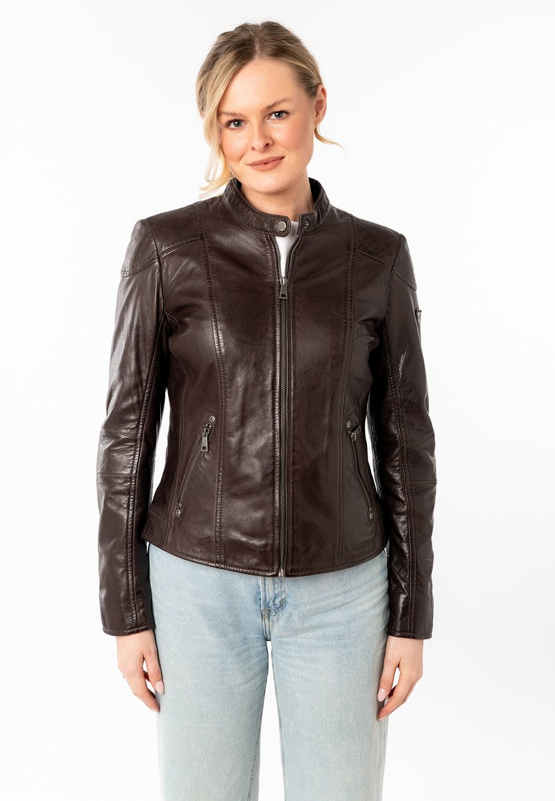 Giacca in pelle marrone con un design aderente, colletto alto e tasche con zip. Presenta una texture liscia e dettagli di cucitura discreti.