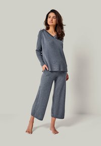 Gray knit loungewear set featuring a V-neck long-sleeve top and wide-leg pants, both made of soft, textured fabric. Comfortable fit.