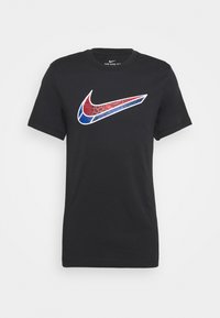 Camiseta de algodón negra con un gran logo Swoosh de Nike en rojo y azul con acentos decorativos. Cuello redondo y mangas cortas.