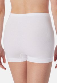 Boxer in cotone bianco con una texture liscia, vita elastica e orlo cucito. Il design offre una copertura completa e una vestibilità aderente.
