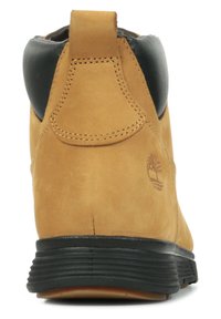 Brun läderankelstövel med en svart krage, texturerad yta och märkeslogotypdetalj på hälen. Robust svart gummisula.