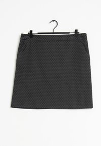Zwarte rok met een gestructureerd patroon van kleine, verhoogde vormen, met zijzakken en een rechte snit, hangend aan een zwarte hanger.