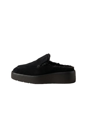 Zapato negro sin cordones con suela gruesa y forro interior peludo, diseñado para uso casual y comodidad.