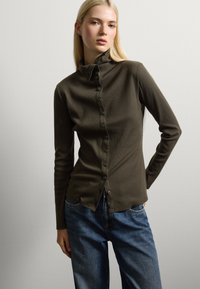 Olivengrünes, langärmeliges Button-Up-Hemd mit hohem Kragen und gerippter Textur. Verfügt über eine durchgehende Vorderseite mit Knopfleiste und einer taillierten Silhouette.