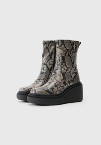 Snake-print ankle boots with a smooth texture, featuring a tall, wedge black sole and a front zipper closure for easy wear.