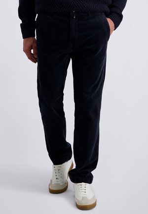 Navy corduroy pants featuring a straight-leg design, textured fabric, button closure, and side pockets, paired with white athletic shoes.