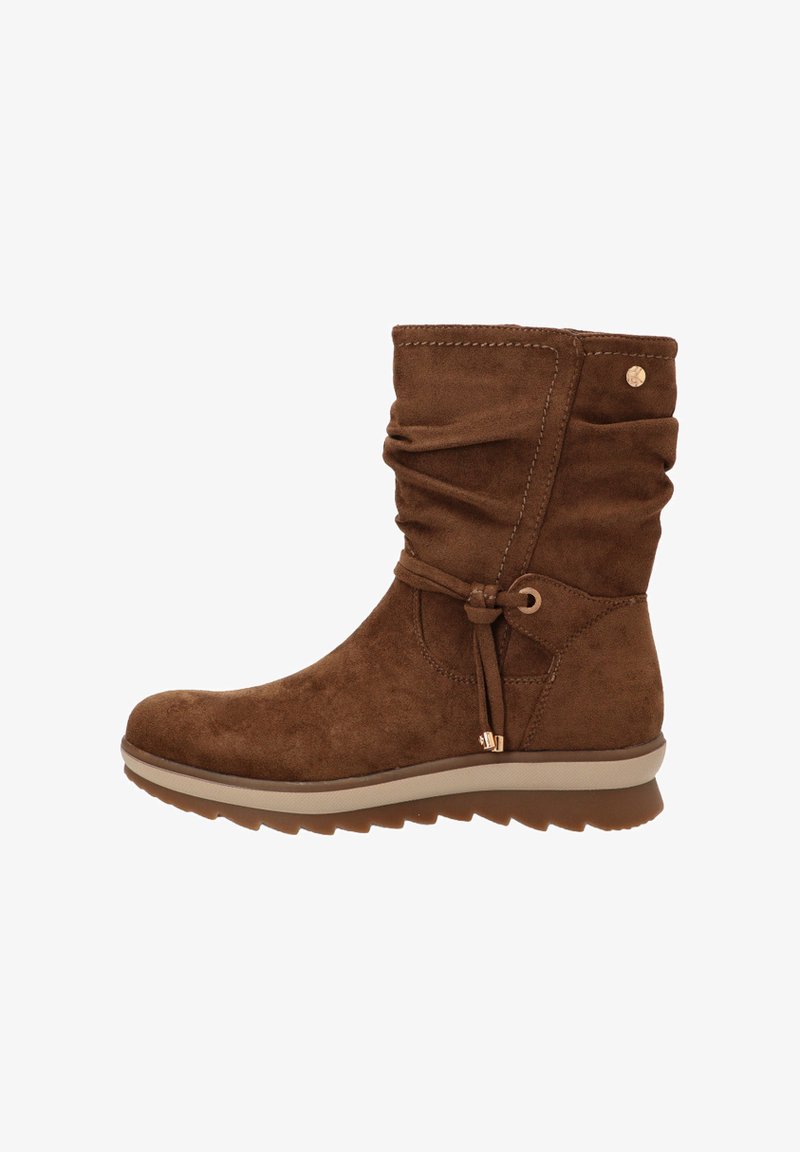 Botín de ante marrón hasta el tobillo con diseño arrugado, lazo decorativo y suela de goma color crema. Presenta un pequeño emblema dorado en el costado.