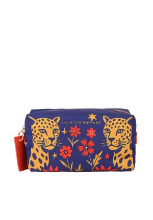 Bolsa azul marino con cremallera, con caras de leopardo amarillas, flores rojas y estrellas doradas, con texto de la marca Lola Casademunt en el frente.