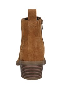 Braune Wildleder-Stiefelette mit einem niedrigen Absatz, Reißverschluss hinten und Ziehlasche, ausgestattet mit einer glatten Oberfläche und einem geriffelten Absatzdesign.