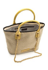 Sac fourre-tout en toile beige avec poignées en cuir jaune et bandoulière chaîne dorée. Bordure noire et doublure intérieure rayée avec une poche zippée.
