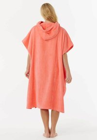 Poncho corallo con cappuccio realizzato in morbido tessuto testurizzato. Presenta un design ampio e un cappuccio regolabile. Nessun motivo o dettaglio aggiuntivo.