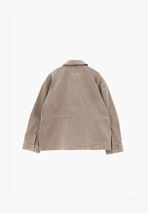 Beige long-sleeve jacket with collar, buttoned cuffs, visible stitching, and a small rectangular label near the bottom hem on the back.